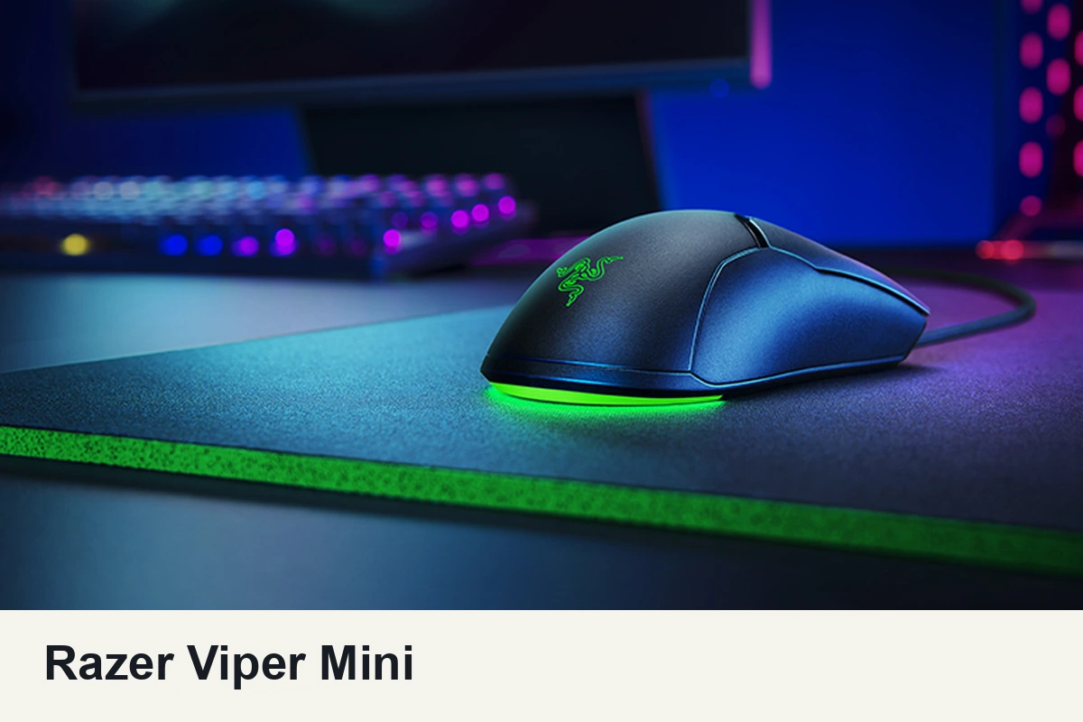 Razer Viper Mini wired gaming mouse on a gaming desk with green lighting beneath the shell